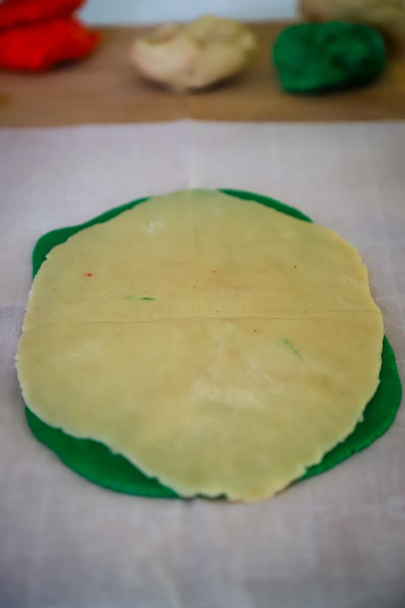 Two layers of colored dough rolled out and placed on top of each other. 