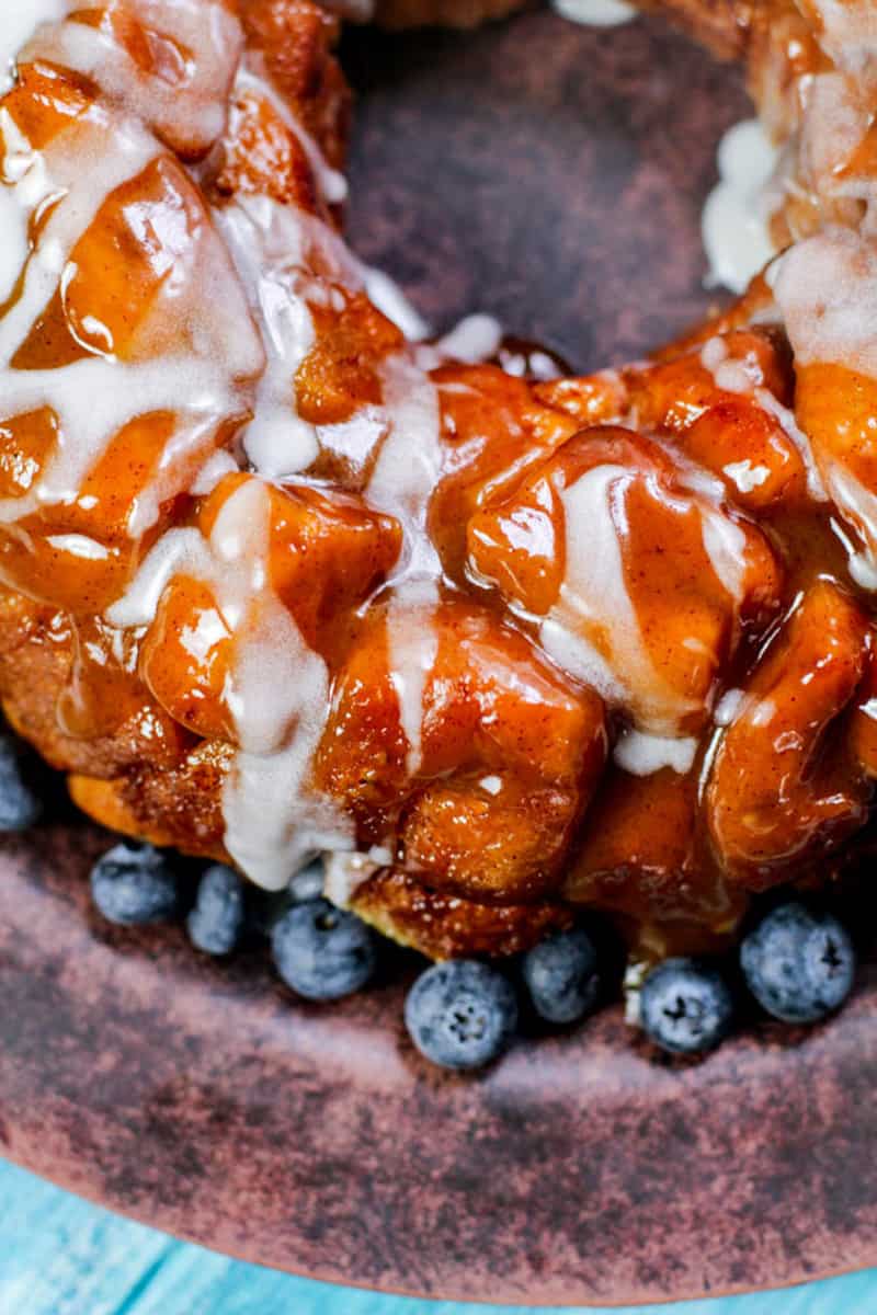 Up close shot of the baked and glazed monkey bread with a rim of fresh blueberries.