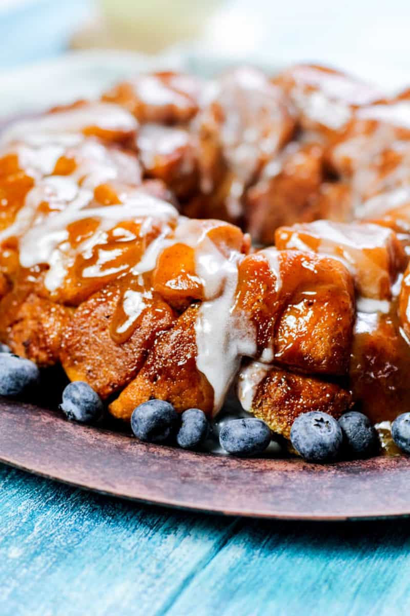 Up close shot of the glazed monkey bread on a wooden plate.