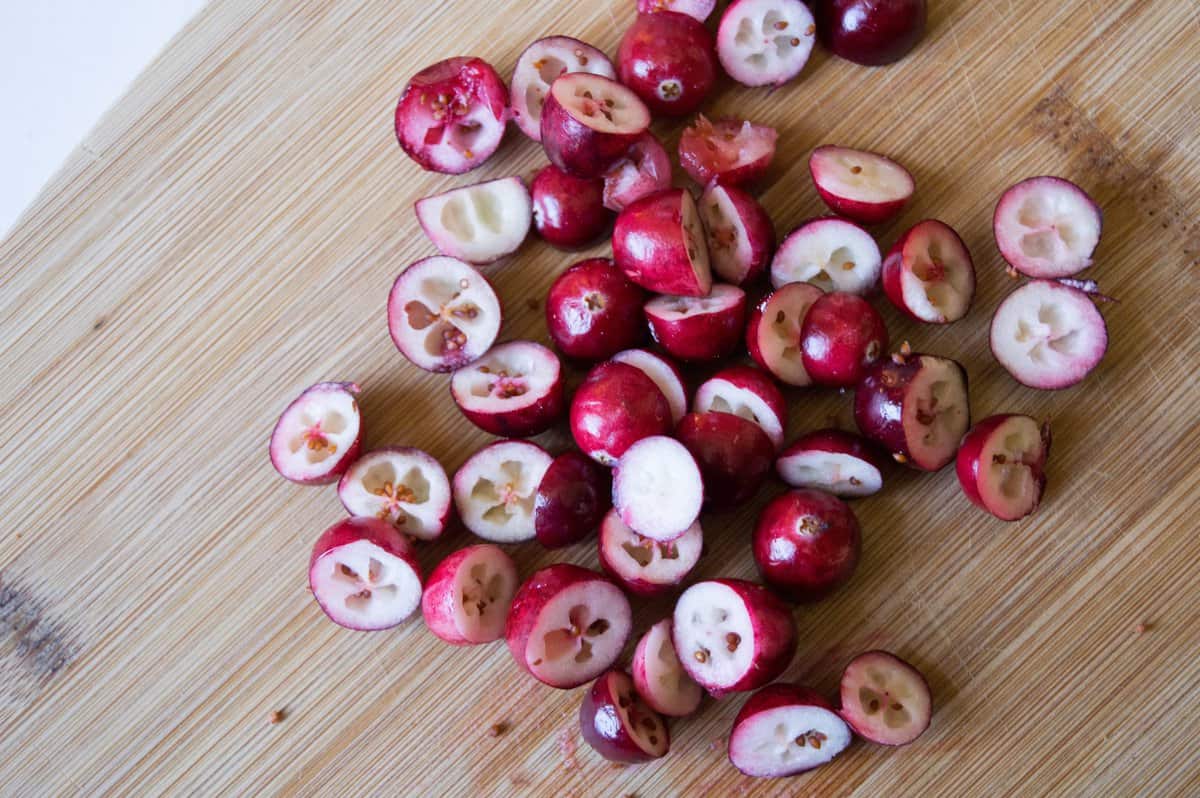 Chopped cranberries on a wood cutting board. 