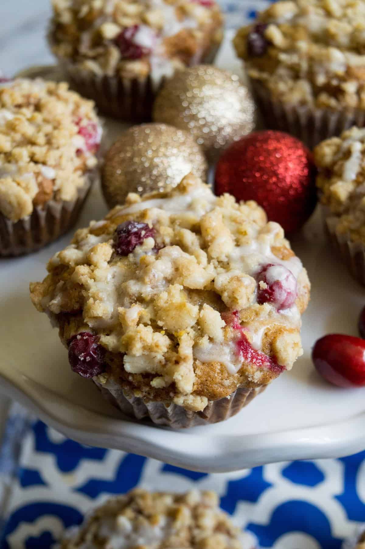 Close up shot of the muffins on cake plate with blue and white dishtowel in background. 