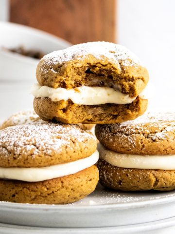 Gingerbread whoopee pies on white plate feature image.