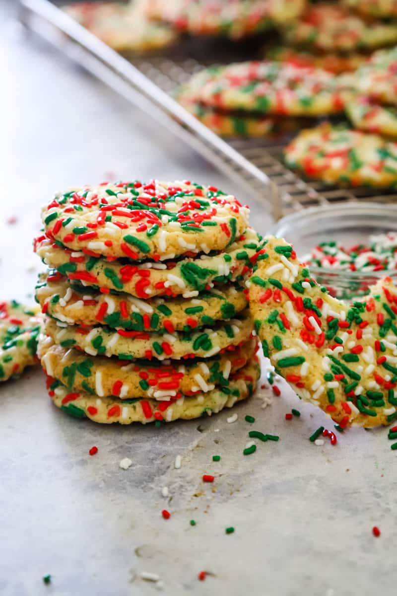Stacked cookies with sugar cookies on a wire rack in background. 