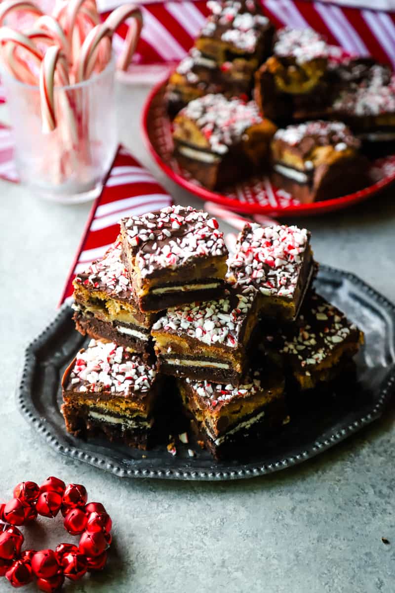 Peppermint Chocolate Brookies on a metal plate with a stack on a red plate in the background. 