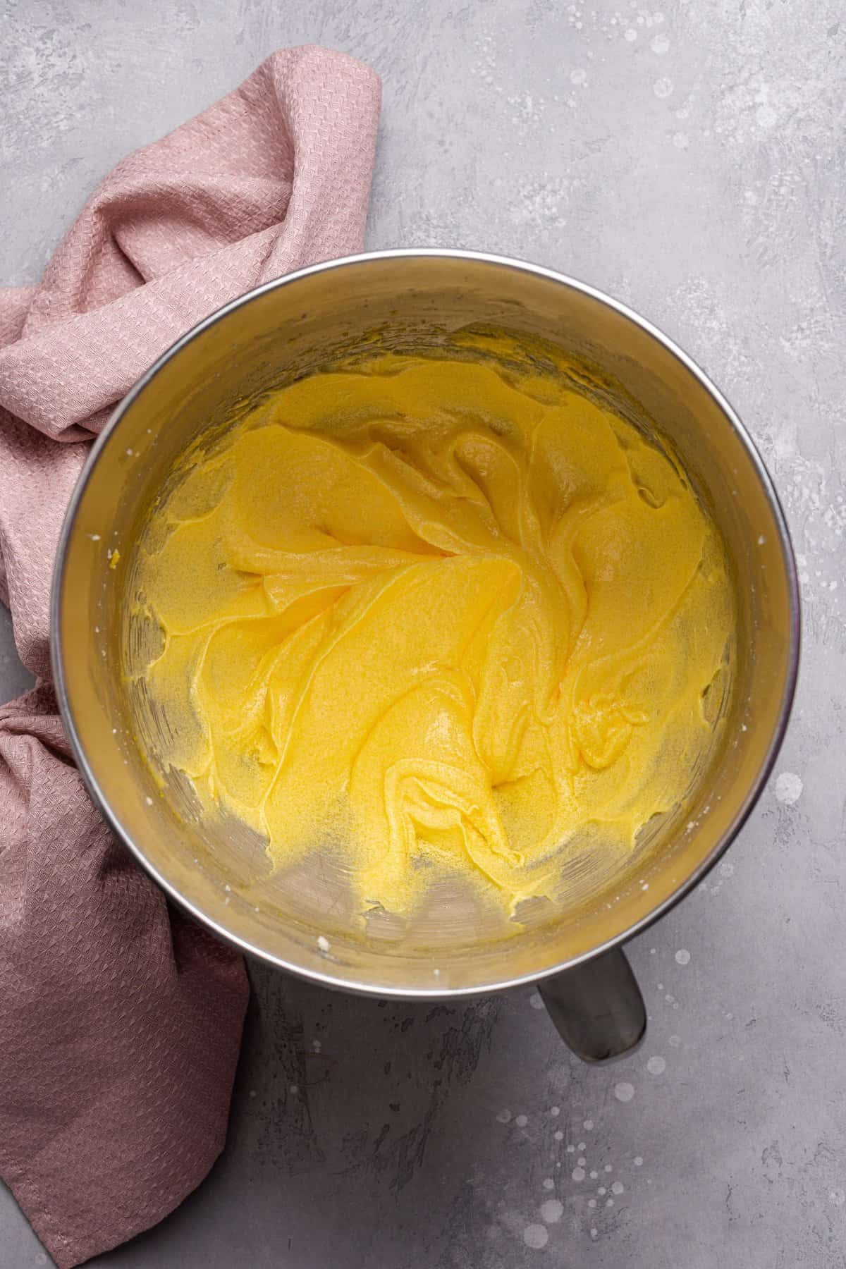 Beating the eggs, oil, butter, and sugar together in a metal bowl. 