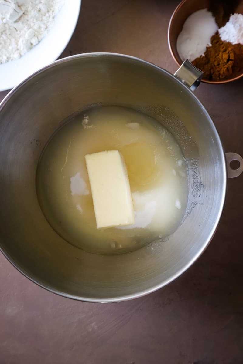 Adding sugar, butter, and oil to a large metal bowl for creaming. 