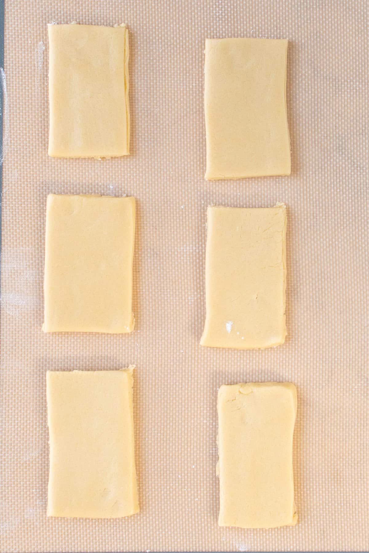 shortbread dough cut into rectangles on parchment paper. 