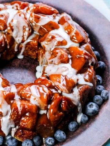 square image of cinnamon roll monkey bread on wooden plate.