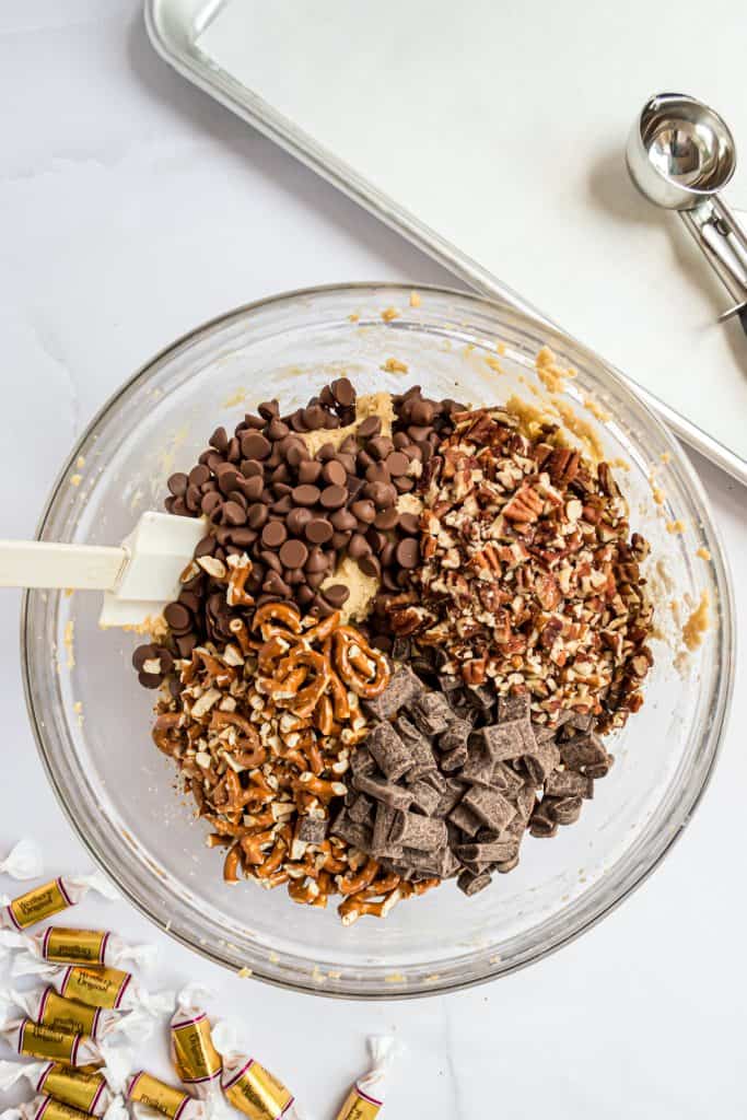 glass bowl with cookie dough and chocolate chips, pretzel pieces and toffee bits. 