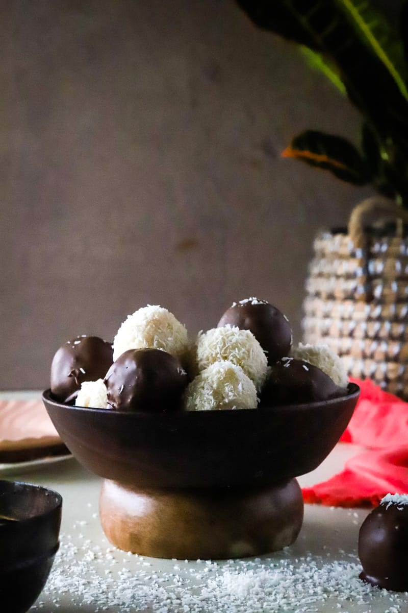 Finished balls in a wooden bowl with wood pedestal and plant in the background. 