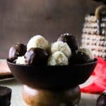 Square feature image of coconut balls in a wooden bowl.