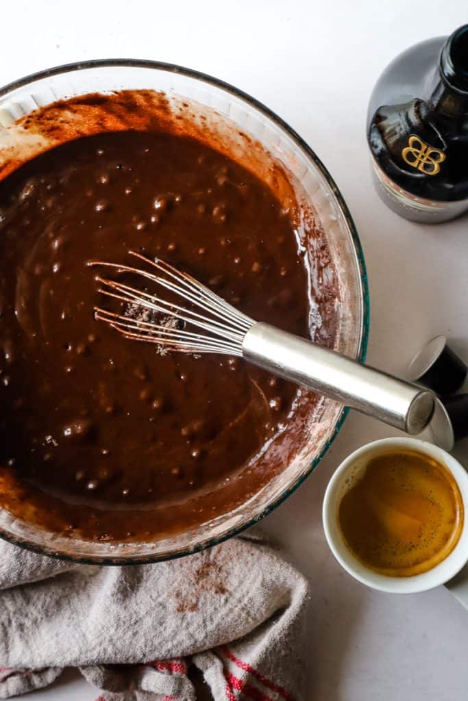 All of the chocolate cake ingredients whisked together in large glass bowl. 