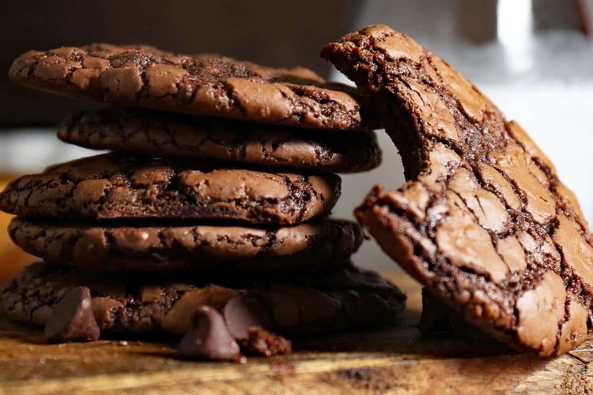 Stacked cookies with one cookie leaning on side with bite taken out. 