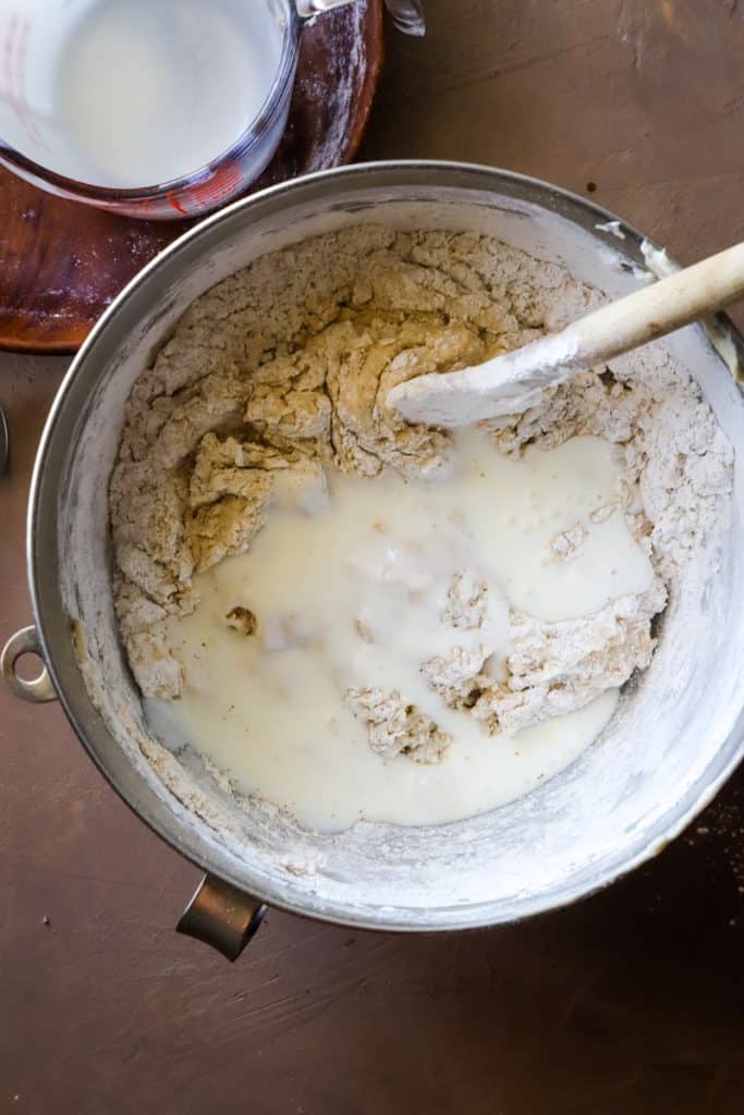 Doing a final stir of the buttermilk into the batter in metal bowl with spatula. 