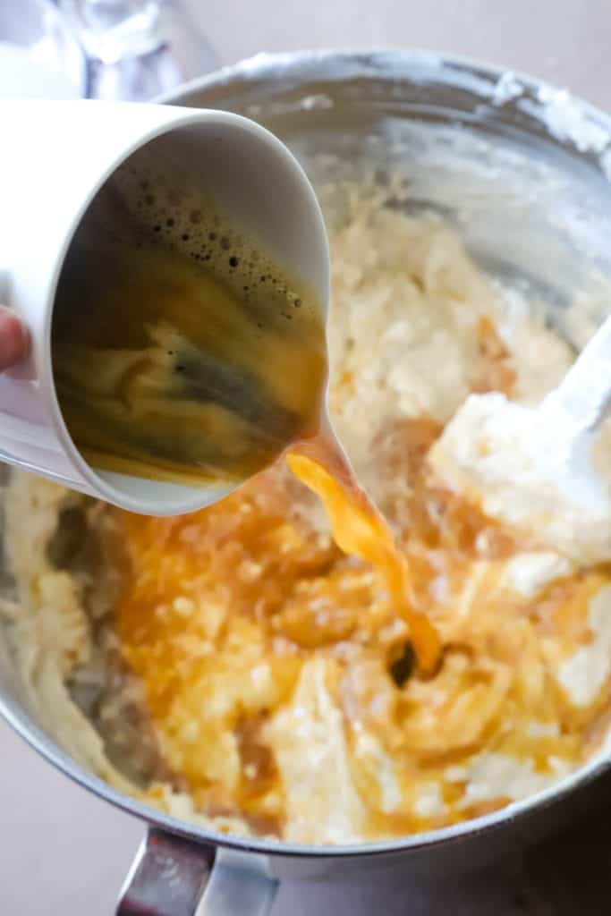 Pouring in the hot coffee into the metal bowl with the cake batter. 