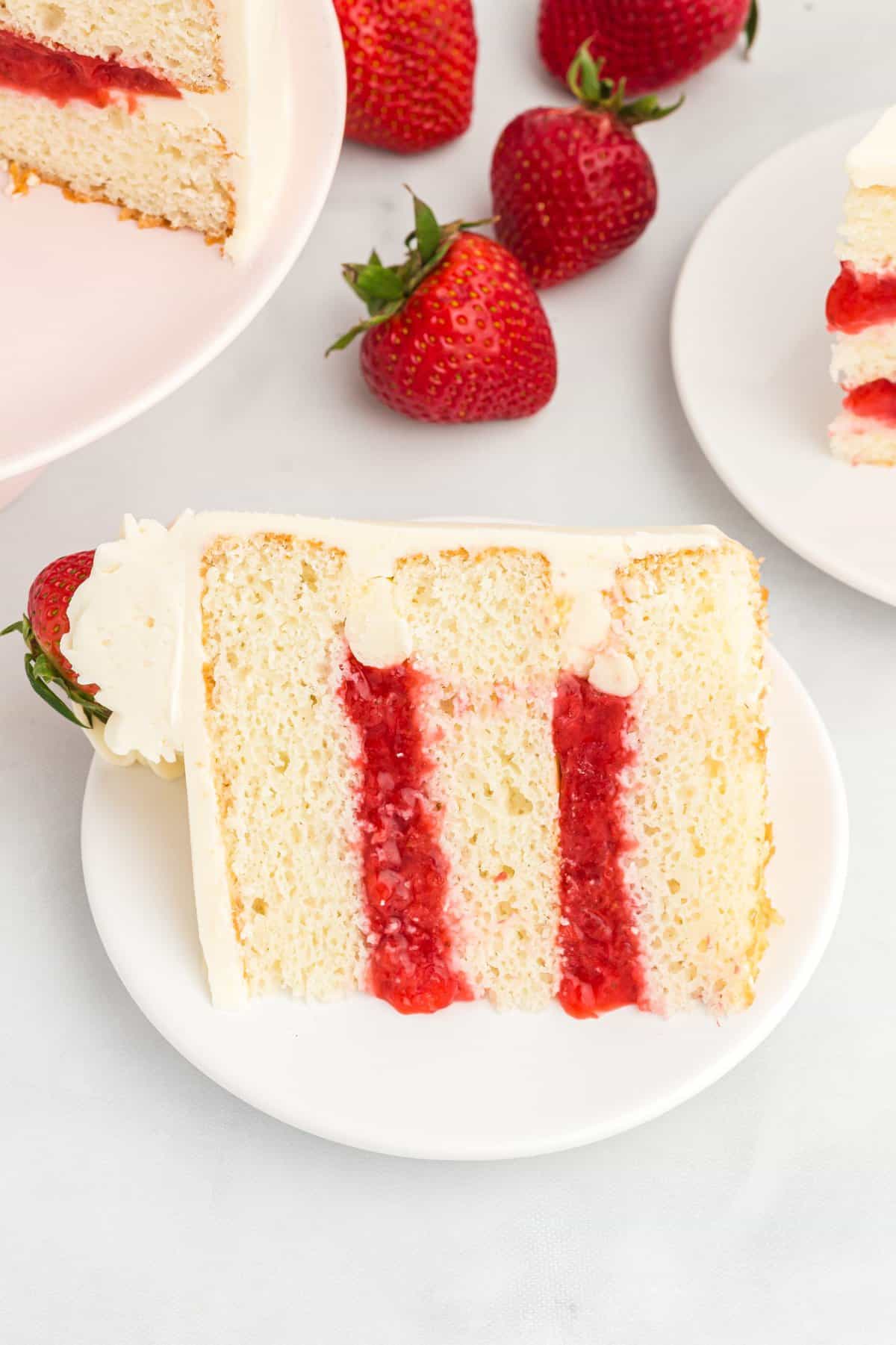 Slice of cake on a white plate to shot the strawberry filling.
