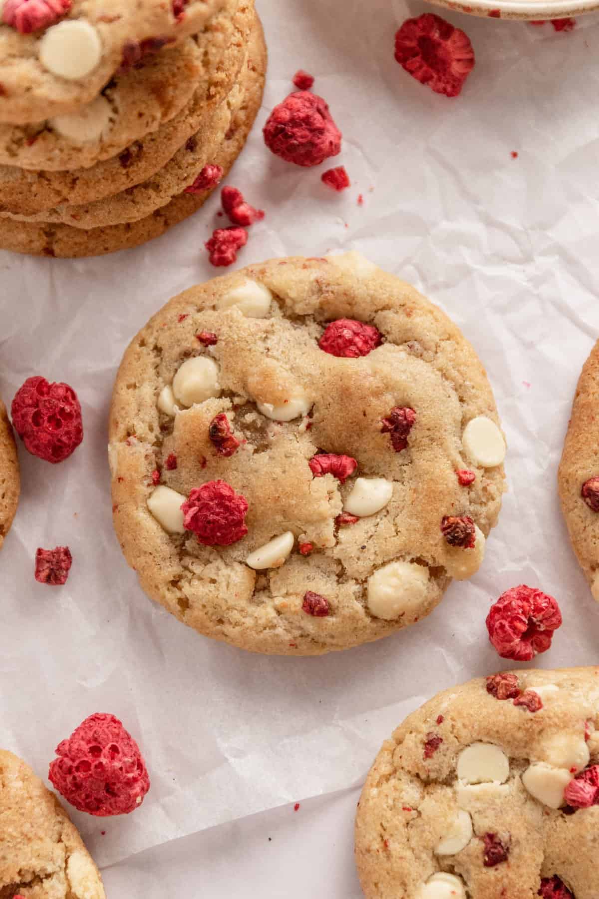 Up close shot of a cookie with white chocolate chips and freeze dried raspberries. 