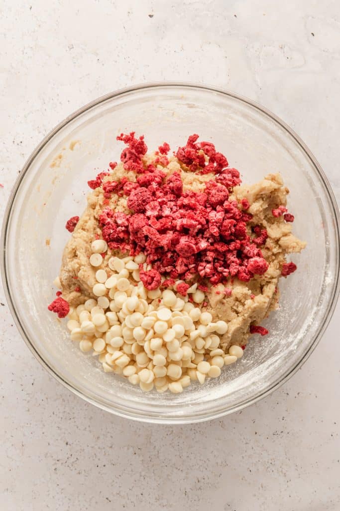 Adding the freeze-dried raspberries and white chocolate chips to the cookie dough. 