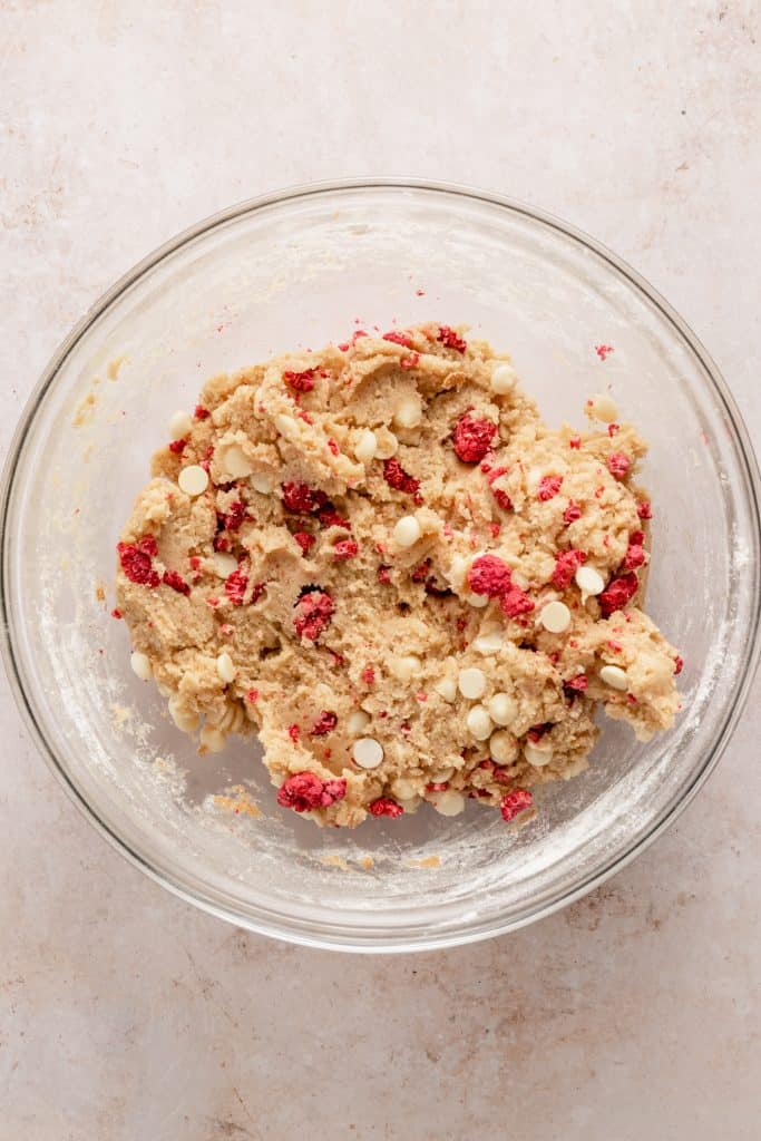 Mixing the cookie dough, raspberries, and white chocolate chips in large glass bowl. 