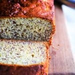 sliced banana bread on a wood cutting board showing the inside of the loaf.