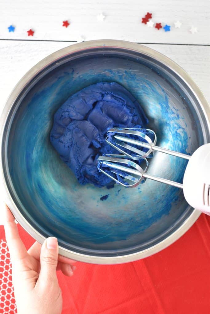 hand mixer mixing in the blue dye to the sugar cookie dough. 