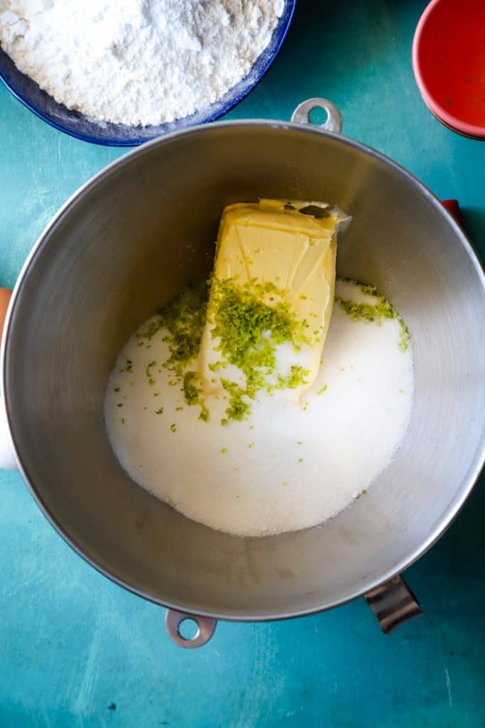 Butter, sugar, and lime zest in a large metal mixing bowl. 
