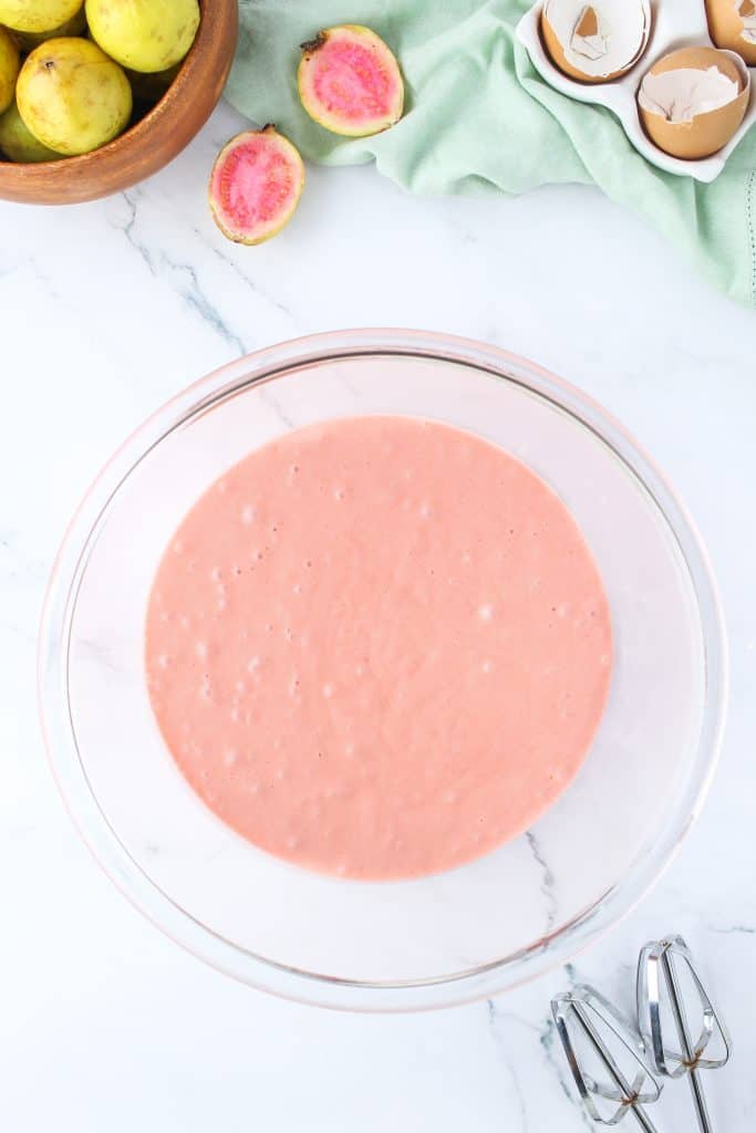 Finished strawberry guava cupcake batter in a glass bowl on marble background. 