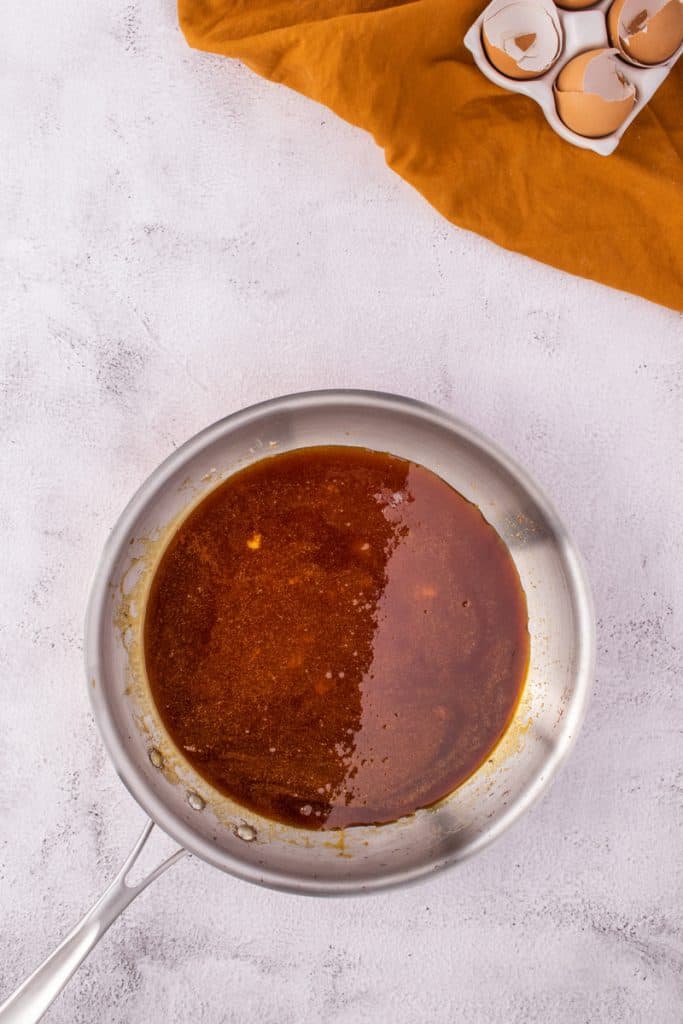 Overhead shot of the caramel in a metal pan on white surface