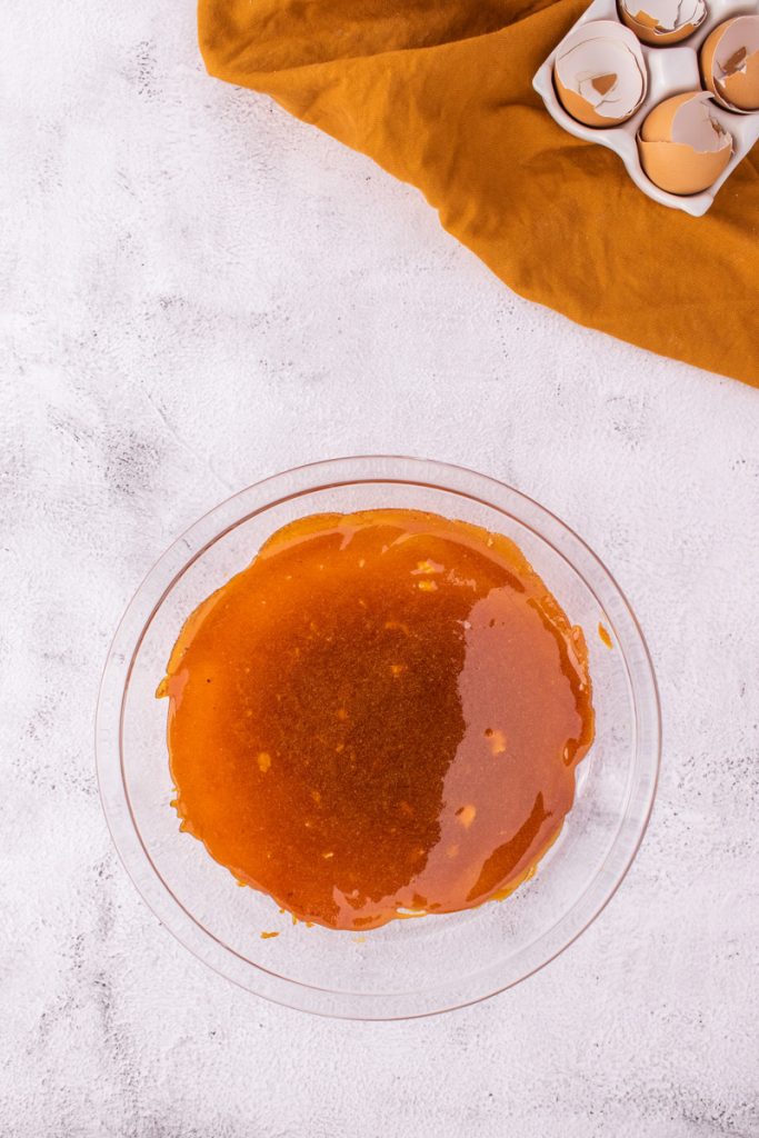 Adding the caramel to a glass dish on a white background,