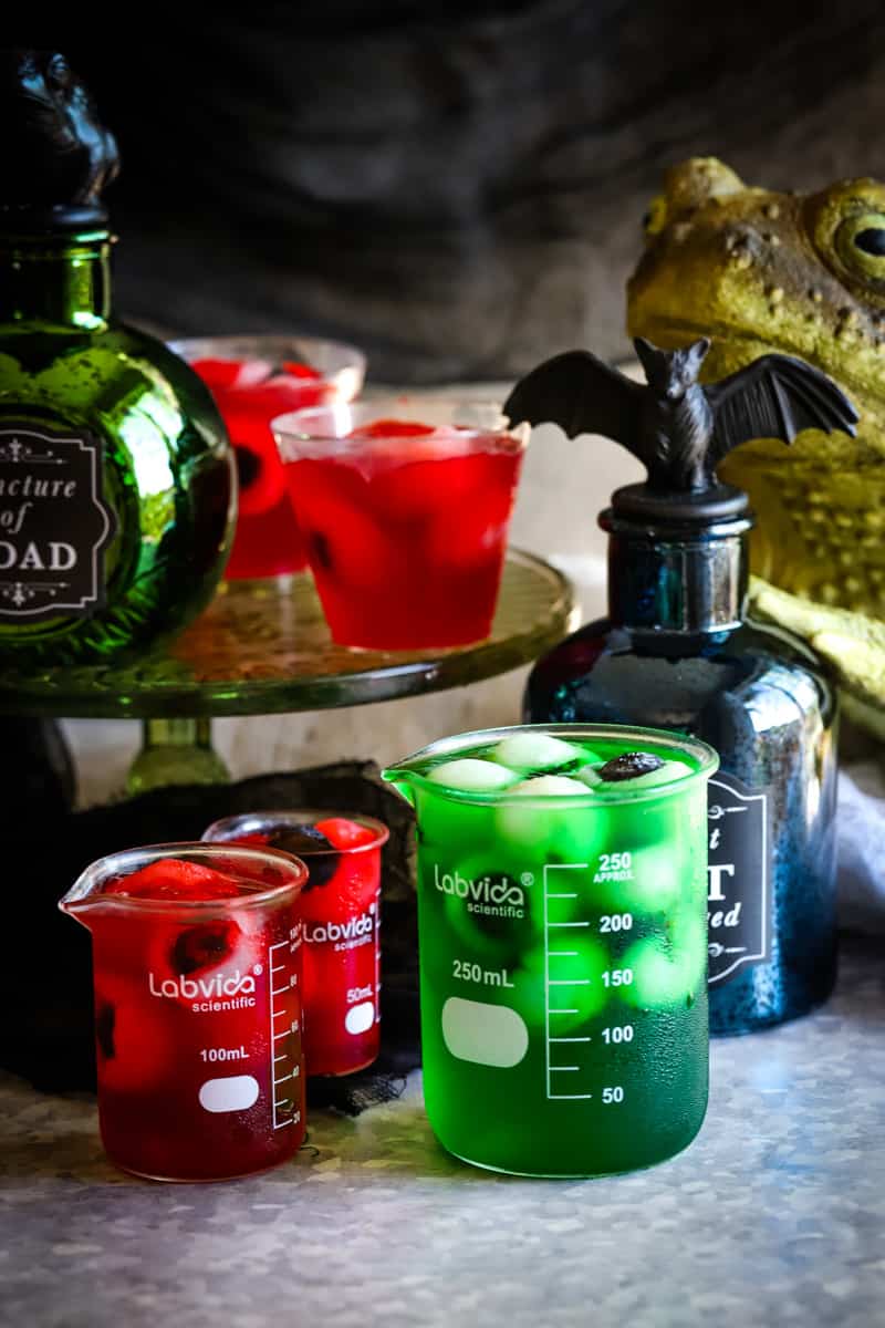 Shot of the jello shots and halloween styled jars and a large frog in background. 