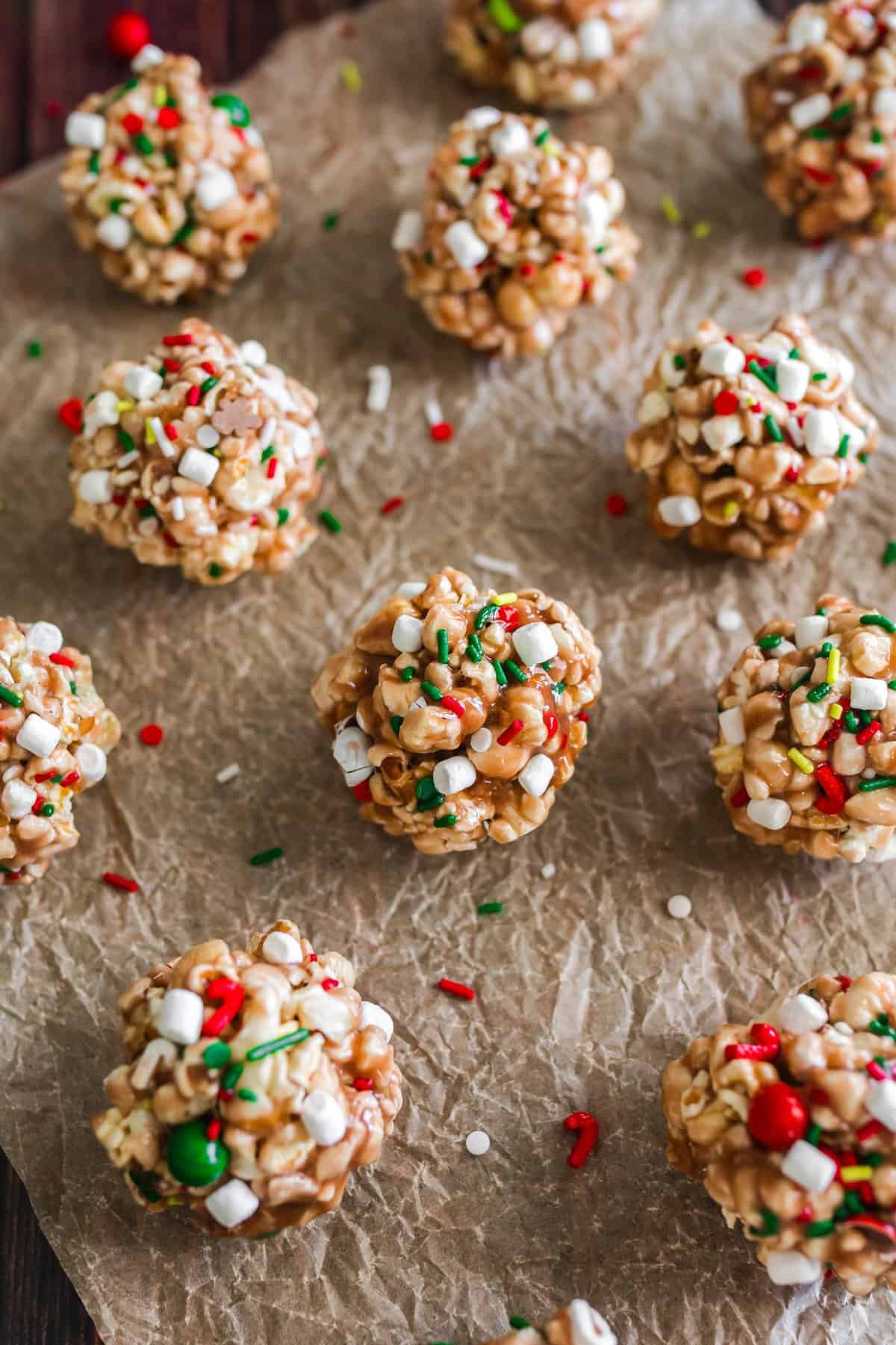 Up close shot of the hot cocoa popcorn balls on brown parchment paper. 