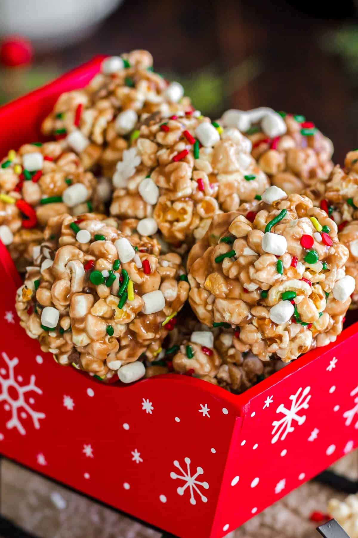Up close photo of the popcorn balls stacked in a red sleigh. 
