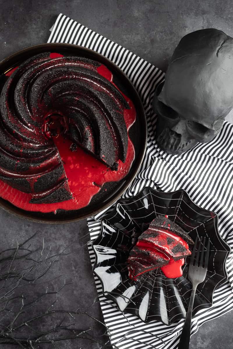 Overhead shot of the bundt cake next to a skull and a spiderweb plate with slice of cake. 