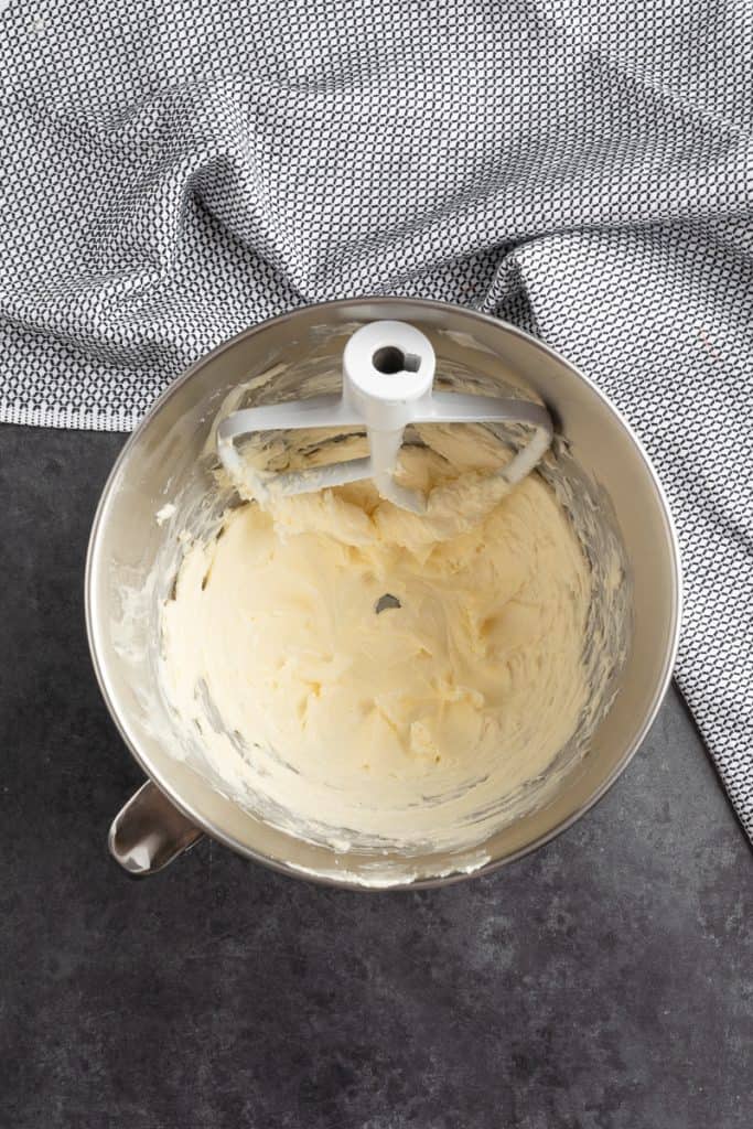 Overhead shot of mixing bowl with paddle attachment and butter and sugar creamed. 