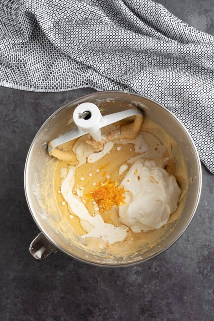 Adding the orange zest and sour cream to the butter/sugar/egg mixture in mixing bowl. 