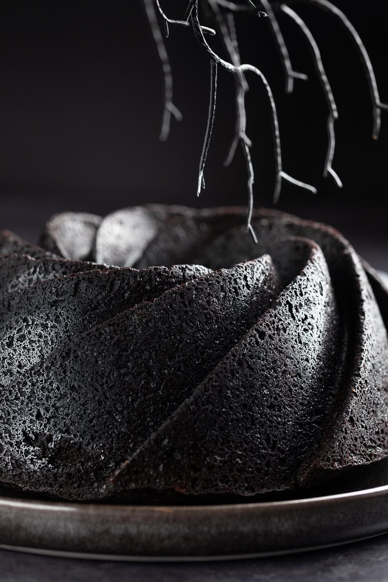 Up close shot of the black bundt cake on a black cake platter. 