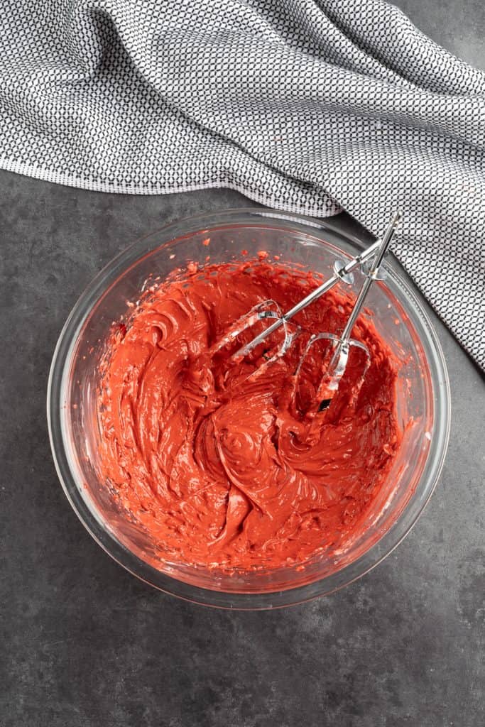 Mixing up all of the cream cheese center until its fluffy and red in a large glass bowl. 