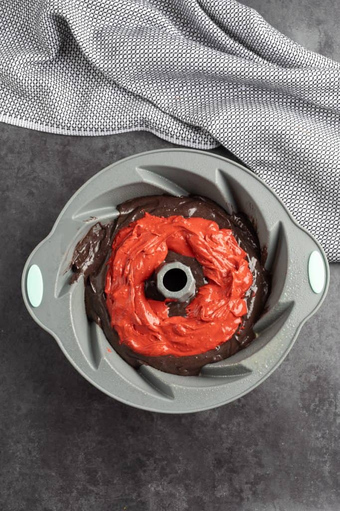 Adding layer of red cream cheese filling to the center of the chocolate bundt cake batter. 