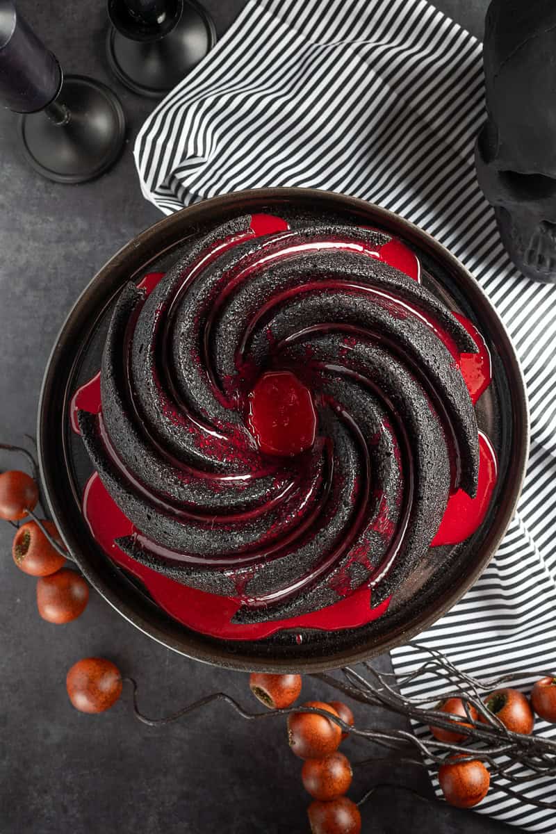 Overhead shot of the spiral black bundt cake with red ganache glaze. 