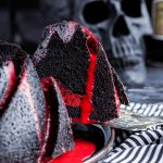 Spooky black bundt cake with blood red white chocolate ganache