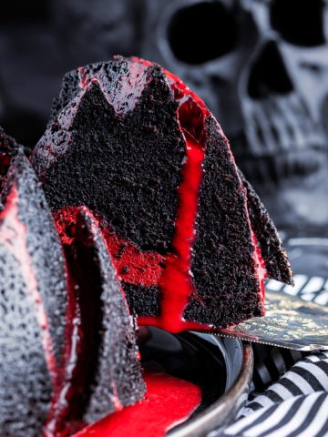 Spooky black bundt cake with blood red white chocolate ganache