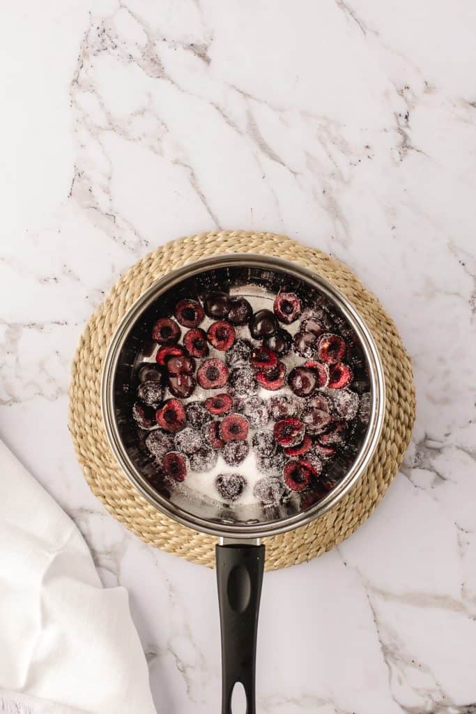 Cherries in a pan with sugar to make the cherry compote.