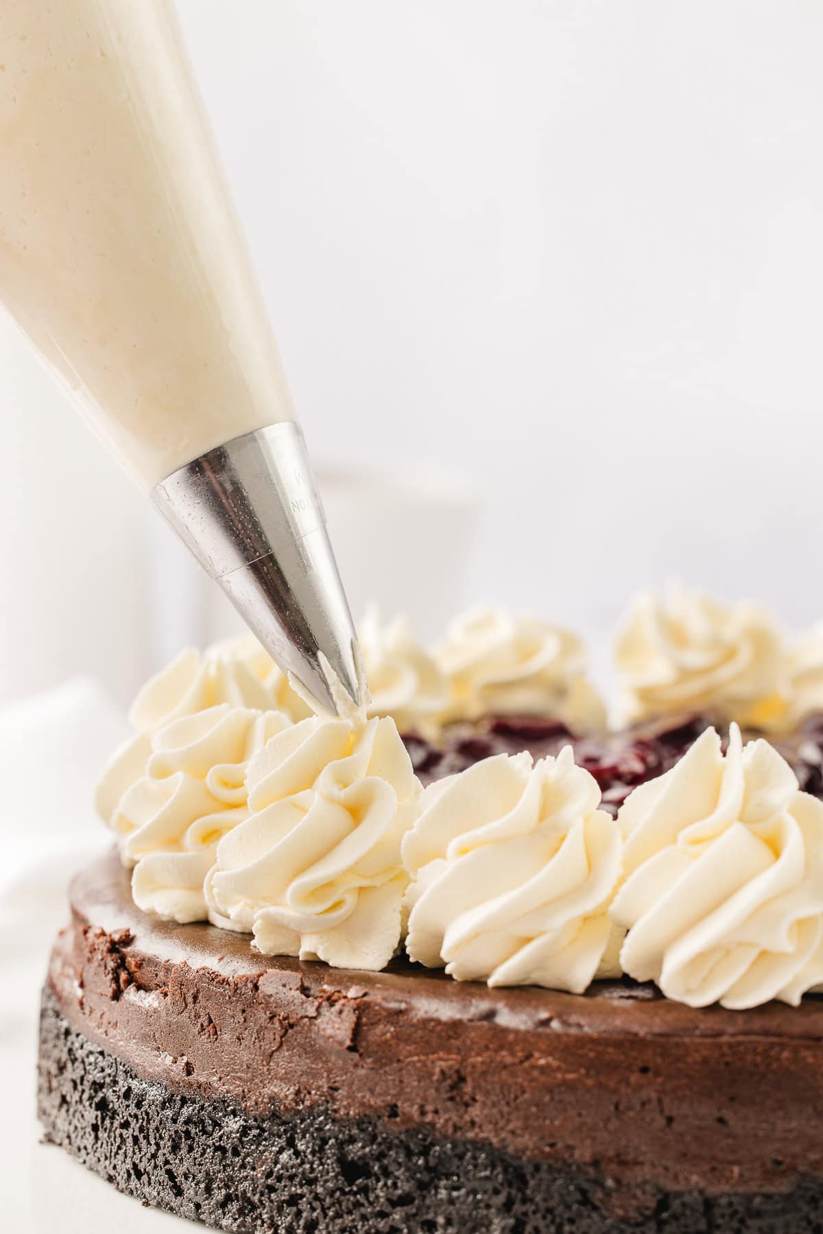 Adding the whipped cream swirls with a pastry bag fitted with a star tip. 