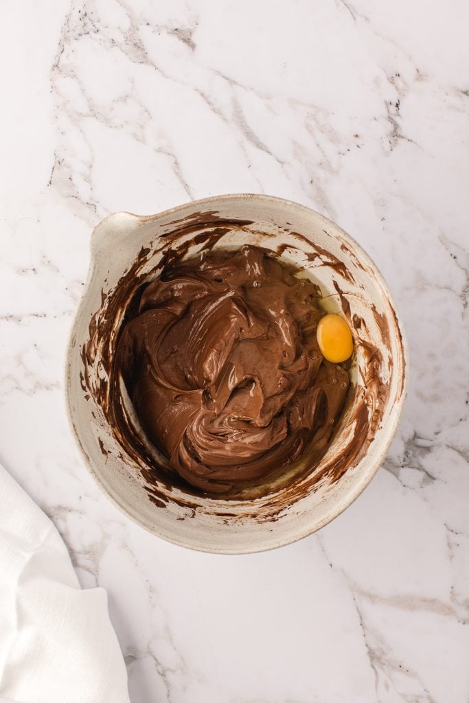 Adding the egg to the chocolate cheesecake filling recipe. 